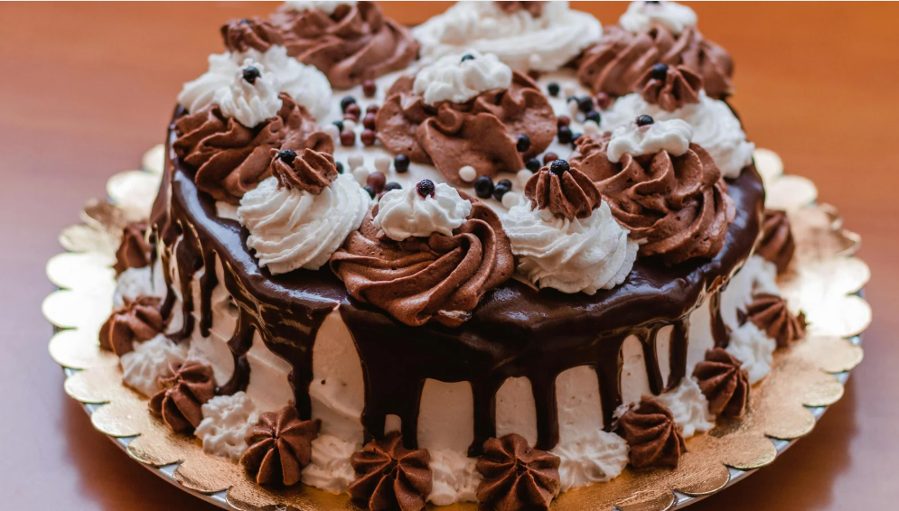 Soft and fluffy homemade vanilla cake on a cooling rack, decorated with buttercream frosting and fresh berries.
