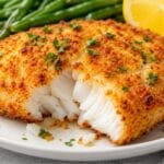 Crispy air-fried cod fillets served with green beans and fresh lemon wedges