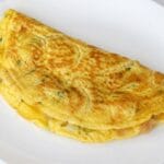 fluffy homemade omelet served on a clean white plate