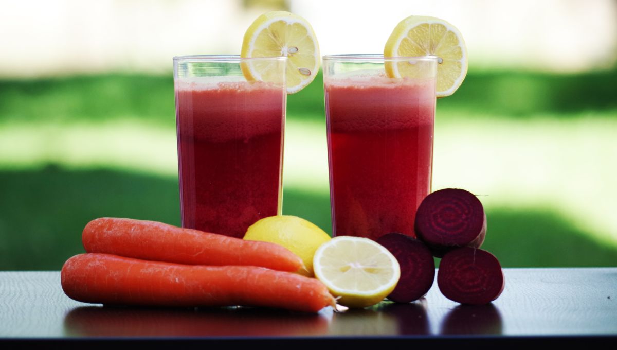 Amla beetroot carrot juice in glass with fresh carrot, beetroot and lemon