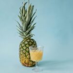 Fresh pineapple juice in a glass with pineapple slices, healthy drink