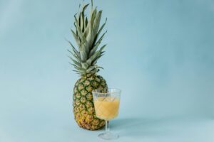 Fresh pineapple juice in a glass with pineapple slices, healthy drink
