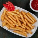 Crispy golden air fryer frozen French fries served with tomato