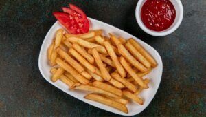 Crispy golden air fryer frozen French fries served with tomato
