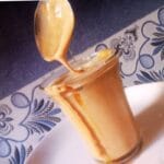 Creamy mocha iced coffee being poured into a glass over ice at home
