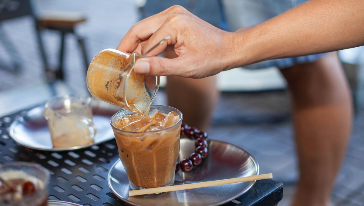 mocha iced coffee being poured over ice in a glass at home